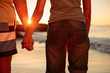 Rear view of a couple hand in hand walking on the beach
