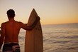 Handsome man holding a surfboard