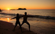 Silhouettes of people practicing yoga on the evening