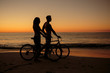 Couple biking together on the beach