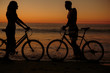 Silhouettes of people on bicycles on the beach