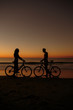 Silhouettes of people facing each other on bikes