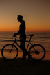 Silhouette of man on his bike on the beach