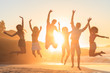 Young people jumping in front of the sunset