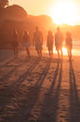 People standing in row in front of the sunset