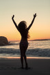 Woman raising arms on the beach