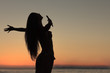 Silhouette of woman spreading her arms on the beach