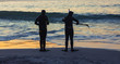 SIlhouettes of people holding snorkeling equipment