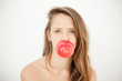 Pretty topless young woman holding a red apple with her mouth