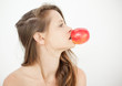 Pretty woman holding a red apple by biting the stalk