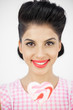 Cheerful young pinup holding a lollipop