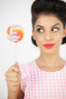 Cute young pinup looking at her lollipop