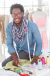 Smiling fashion designer working on a green textile