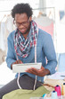 Smiling fashion designer working on a tablet