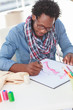Concentrated artistic man with reading glasses drawing clothes