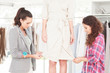 Fashion female designers adjusting a dress