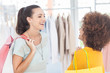 Two attractive friends laughing in a clothing store