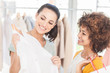 Attractive woman showing her new dress to her friend