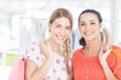 Delighted friends holding shopping bags