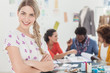 Blonde designer standing with arms folded