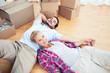Woman lying on her boyfriend on the wooden floor