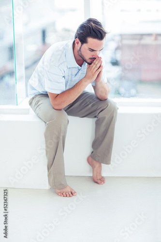 Photo: Anxious handsome man sitting Anxious handsome man sitting