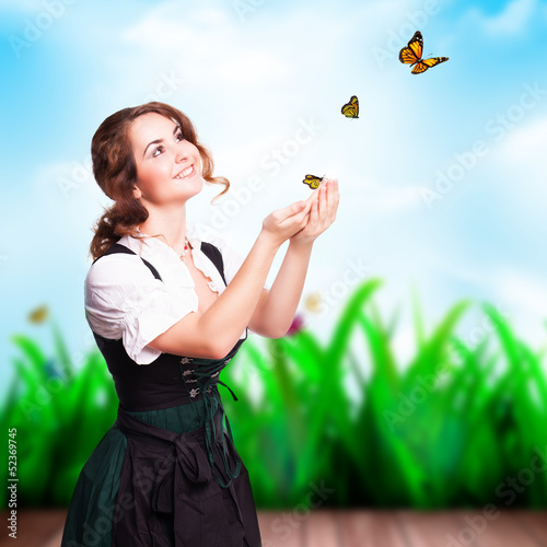 Photo: attraktive junge Frau im Dirndl mit Schmetterlingen attraktive junge Frau im Dirndl mit Schmetterlingen