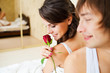 Photo: lovely couple in bedroom. man gives a red rose lovely couple in bedroom. man gives a red rose