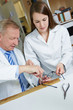 Optiker hilft Azubi bei Reparatur