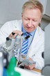 Foto: Optiker in Werkstatt mit Bohrmaschine Optiker in Werkstatt mit Bohrmaschine