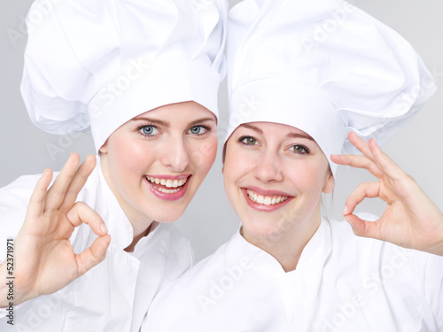 Photo: Two female apprentices for cooking show thumb up Two female apprentices for cooking show thumb up