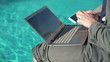 Video: Closeup of businessman working on laptop computer by swimming-po Closeup of businessman working on laptop computer by swimming-po