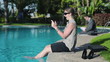Video: Businesswoman sitting by the poolside with cellphone Businesswoman sitting by the poolside with cellphone