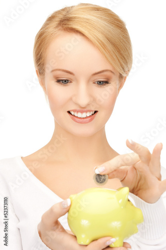 Photo: woman with small piggy bank and coin woman with small piggy bank and coin