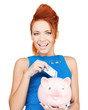 woman putting cash money into piggy bank