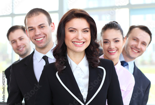 Photo: happy young female business leader standing in front of her team happy young female business leader standing in front of her team