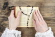 Hands holding the Bible and praying with a rosary