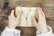 Hands holding the Bible and praying with a rosary