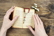 Hands holding the Bible and praying with a rosary