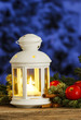 Beautiful white lantern on snowy evening landscape. Christmas de