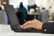 Employee hands working with laptop on the office background