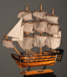 Model sailboat on a gray background.
