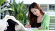 Beautiful young asian student is reading and writing