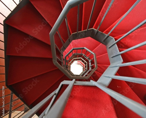 Photo: Iron spiral staircase with elegant red carpet and spiral Iron spiral staircase with elegant red carpet and spiral