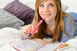 Daydreaming teenager girl writing her journal