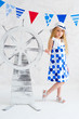 Little girl in fashion dress next to decorative steer wheel
