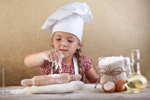 Photo: Little girl stretching the cookie dough Little girl stretching the cookie dough