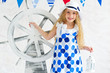 Adorable curly girl in spotted dress holding steer wheel