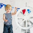 Cute little sailor boy holding a steer wheel