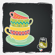 Hand drawn tea cups and a teabag on chalkboard background